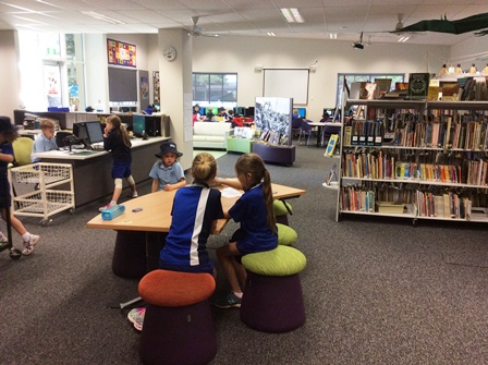 students sitting and standing in resource centre